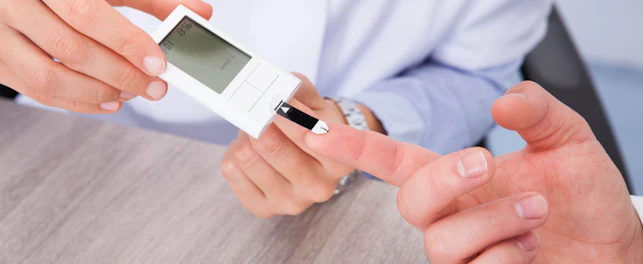 Close-up Of Doctor Holding Patient's Finger Checking Sugar Level